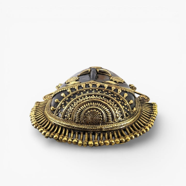 Bottom angled view of handcrafted Bastar art brass mask highlighting ornate headgear detailing and traditional Dhokra metal craftsmanship