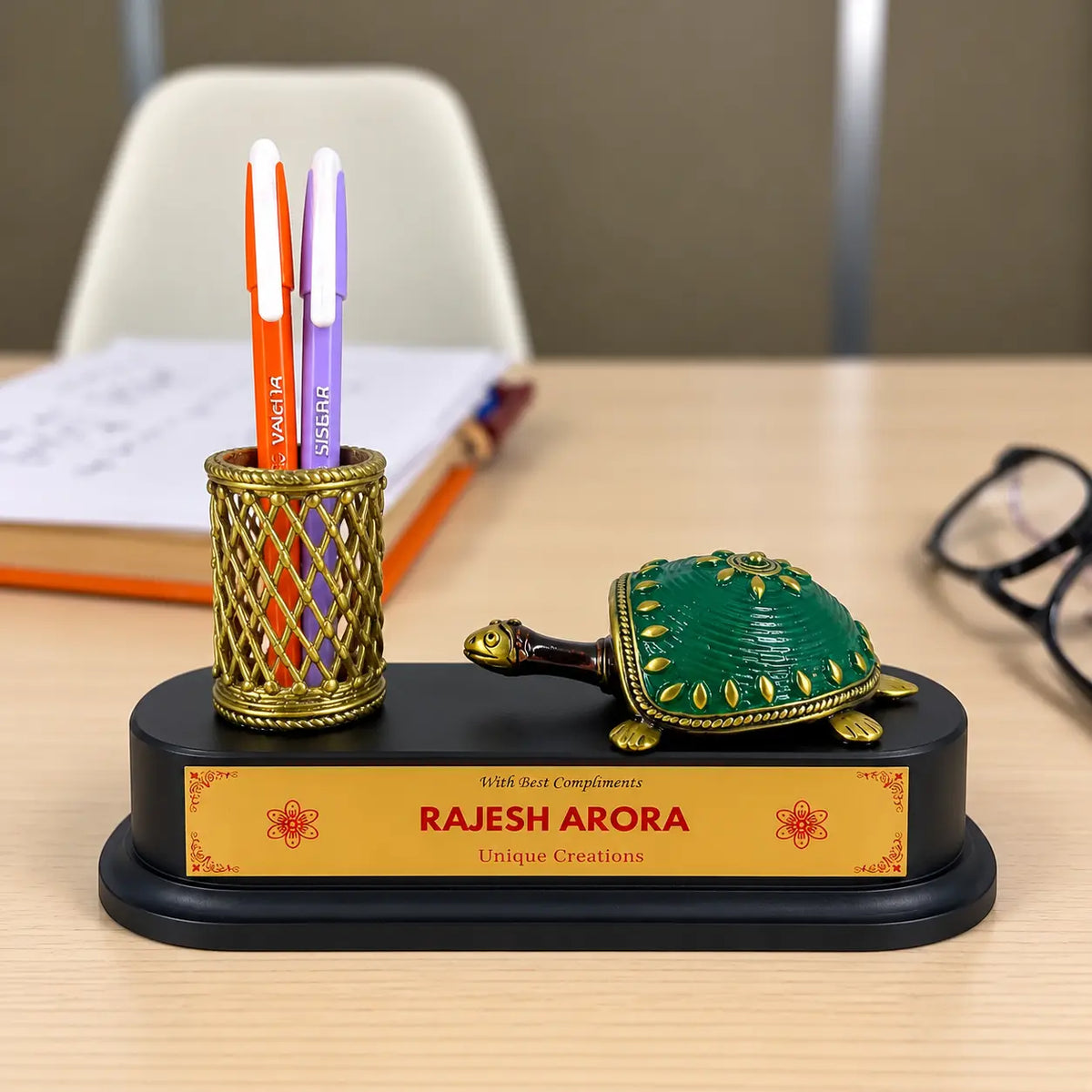 Bastar Dhokra brass tortoise with green shell and brass pen holder on a black wooden base with personalized gold name plate and a pen