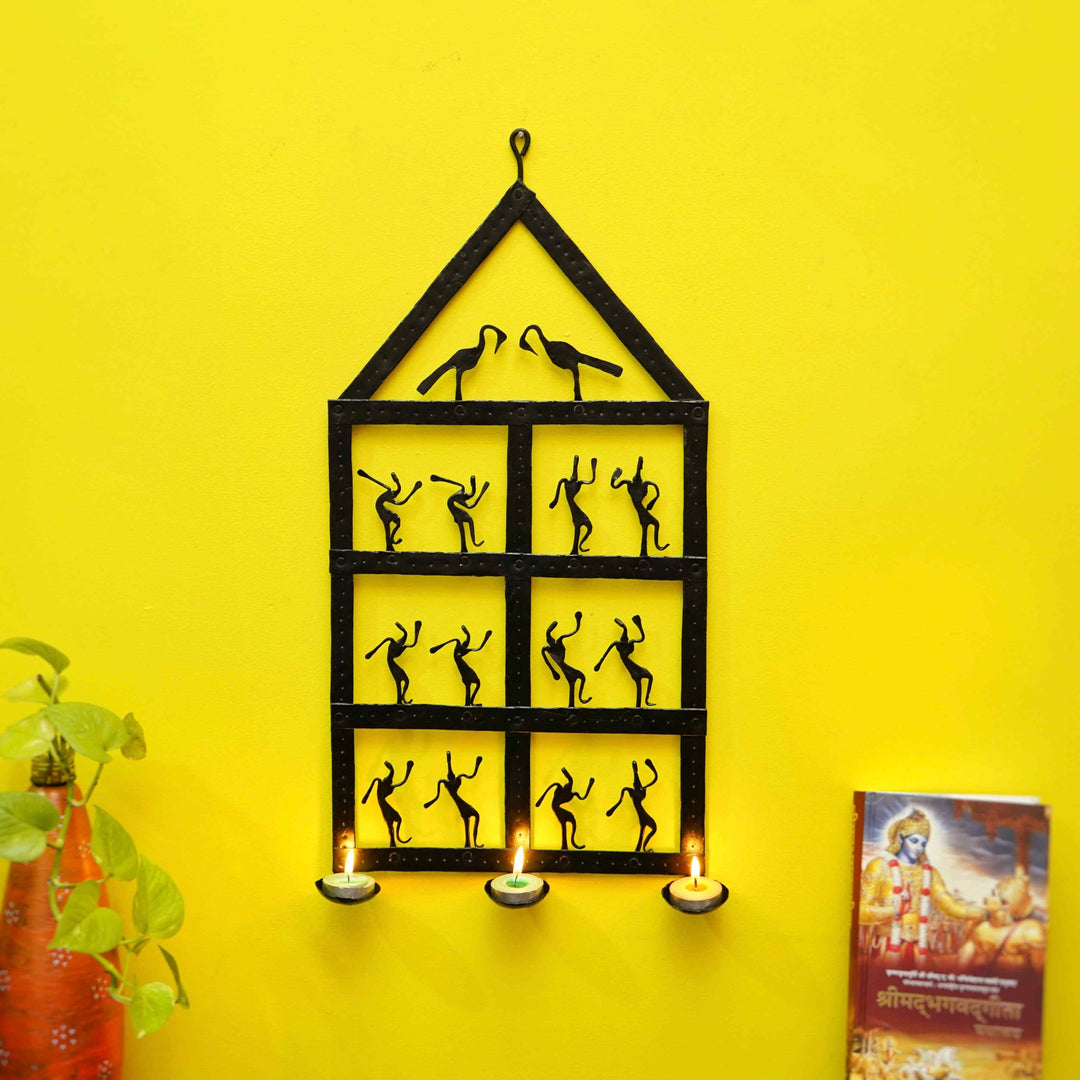 Handcrafted Bastar iron art dancing home wall hanging with tea light holders tribal metal wall decor on yellow wall lifestyle display