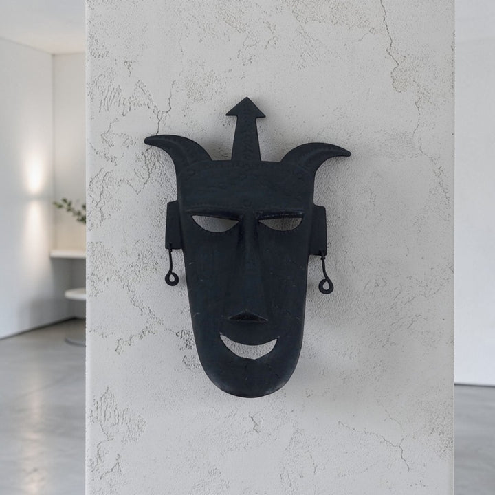 Handcrafted Bastar iron art trident mask wall hanging in black finish displayed on wall in a lifestyle setting for home and office decor