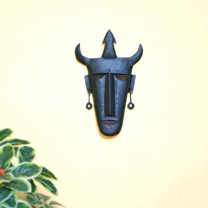 Handcrafted Bastar iron art trident mask wall hanging in black finish displayed on wall in a lifestyle setting for home and office decor
