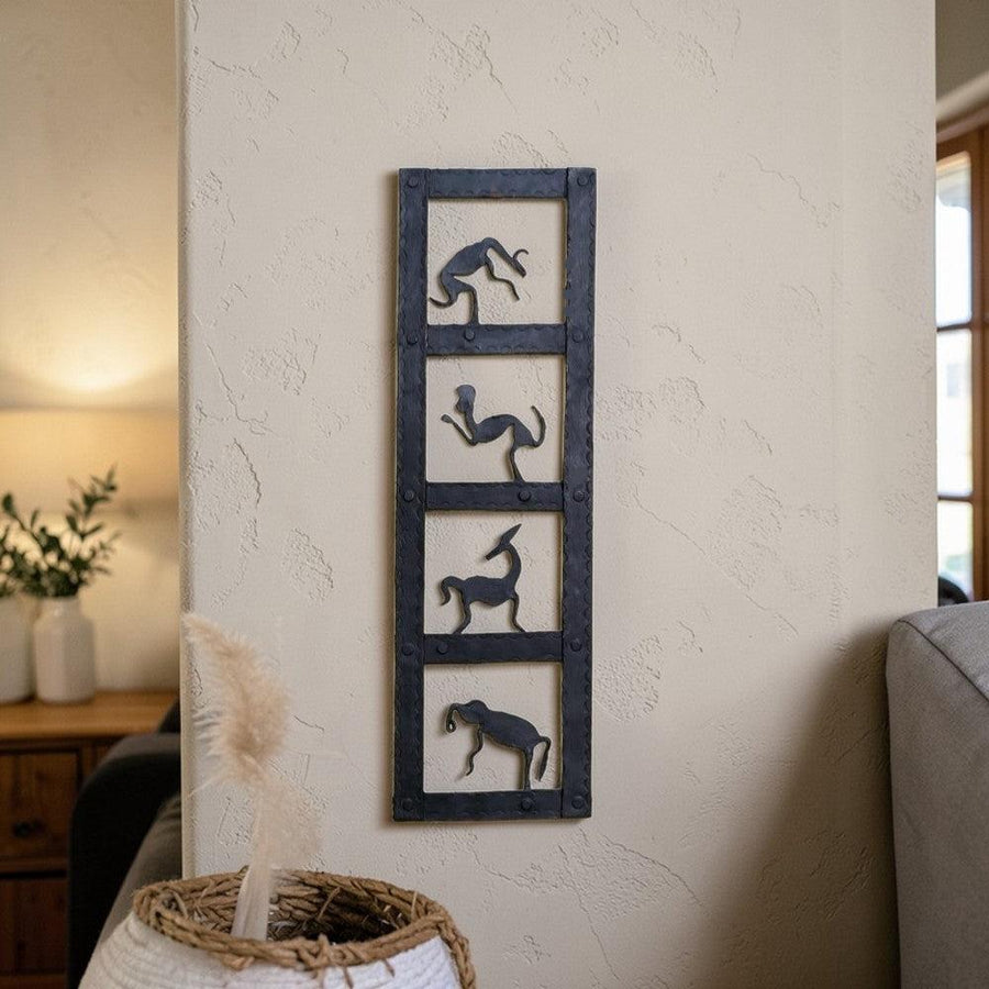Handmade Bastar iron craft animal kingdom wall panel displayed vertically on a wall, featuring minimalist animal silhouettes in black metal