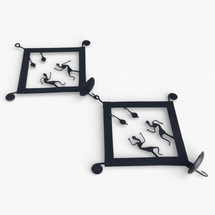 Handcrafted Bastar iron craft square tile tea light wall hanging units photographed at an angle, highlighting detachable panels, dancer figures, and diya holders