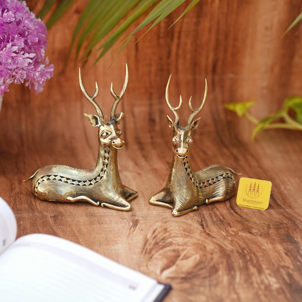 Handcrafted brass bell metal sitting deer duo placed on a wooden surface as elegant home decor showpieces