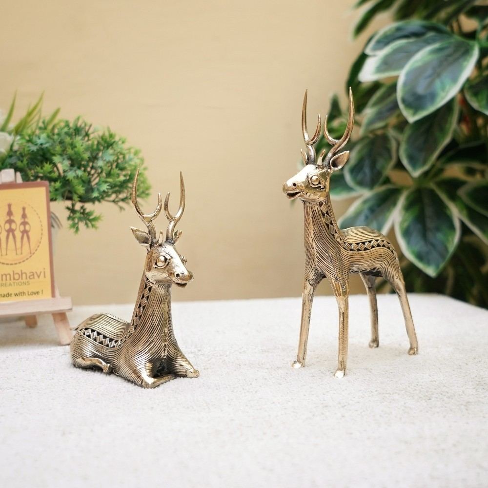 Handcrafted brass deer pair in standing and sitting posture placed on a tabletop, Dokra art animal figurines for elegant home decor