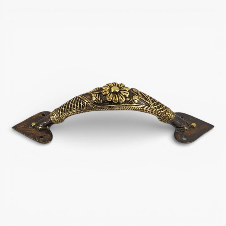 Studio view of bronze finish brass door handle with floral centerpiece and traditional lattice craftsmanship