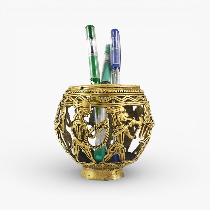 Front view of Dhokra art brass pen holder featuring marching tribal musicians with detailed handcrafted metal work