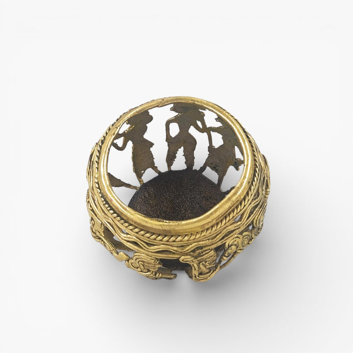 Top view of Dhokra art brass pen holder highlighting circular opening and tribal musician silhouettes