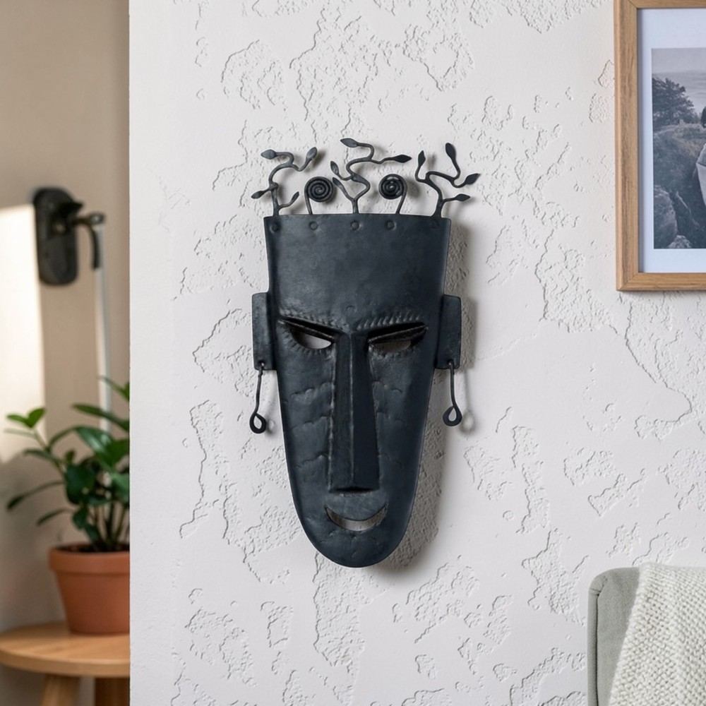 Handmade Bastar iron tribal wall mask with abstract tree crown, black matte finish, displayed on colorful living room wall decor