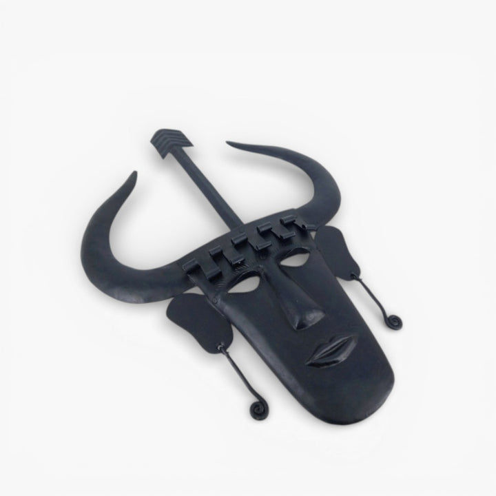 Angled view of handmade Madia tribal Bastar iron wall mask in black showcasing horned design and handcrafted iron texture