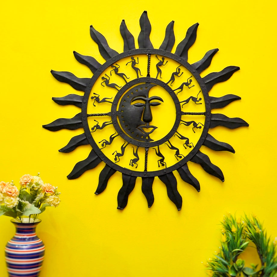 Handmade wrought iron sun moon wall hanging in black finish displayed on a yellow accent wall with plants, Bastar art wall décor