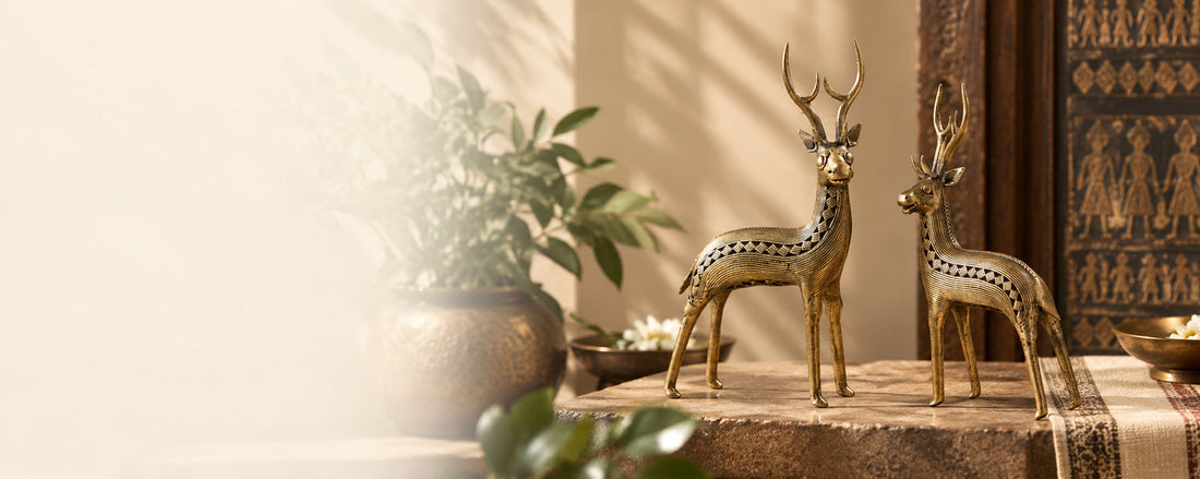 A pair of Bastar Dhokra brass deer on a stone ledge