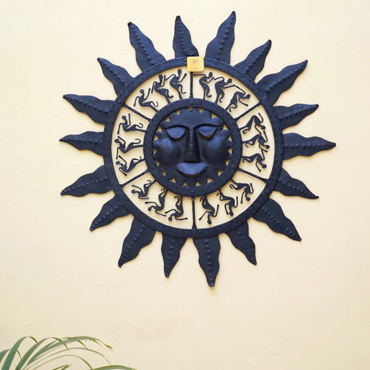 Handmade Bastar iron sun mask wall hanging in black displayed on wall, symbolizing energy and positive vibes for home decor