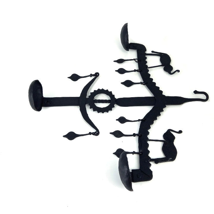 Angled flat lay view of Bastar iron art elephant wall hanging highlighting handmade iron texture and diya bowls