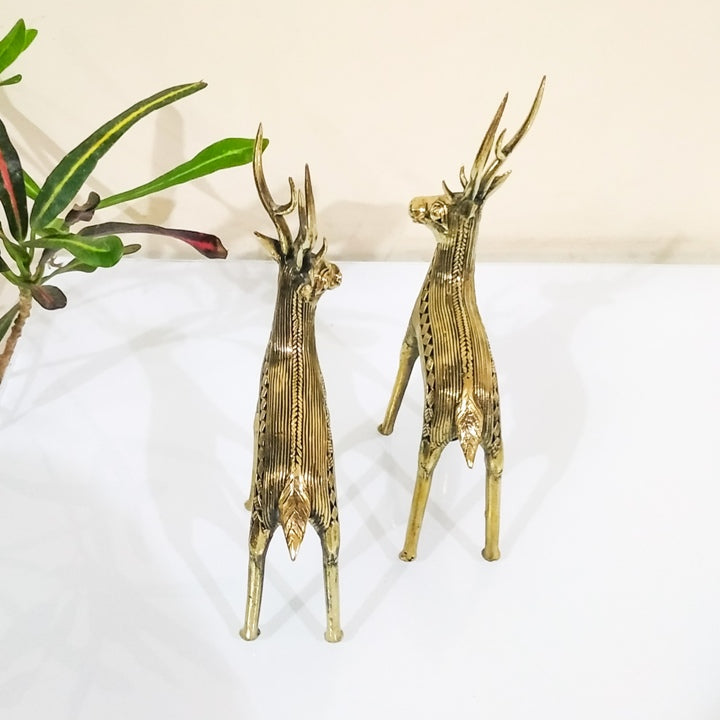 Back angled view of handcrafted brass deer statues highlighting striped body detailing and tall antlers