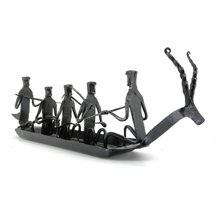 Front angled view of handcrafted Bastar iron art Kerala boat tabletop showpiece featuring tribal figures and rustic black finish