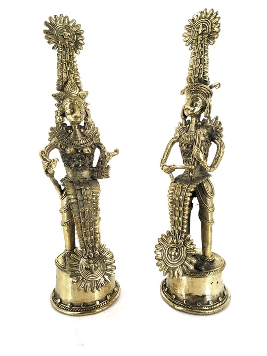 Angled view of brass Jhitku Mitki tribal couple statue highlighting musical instruments and intricate Dokra art motifs