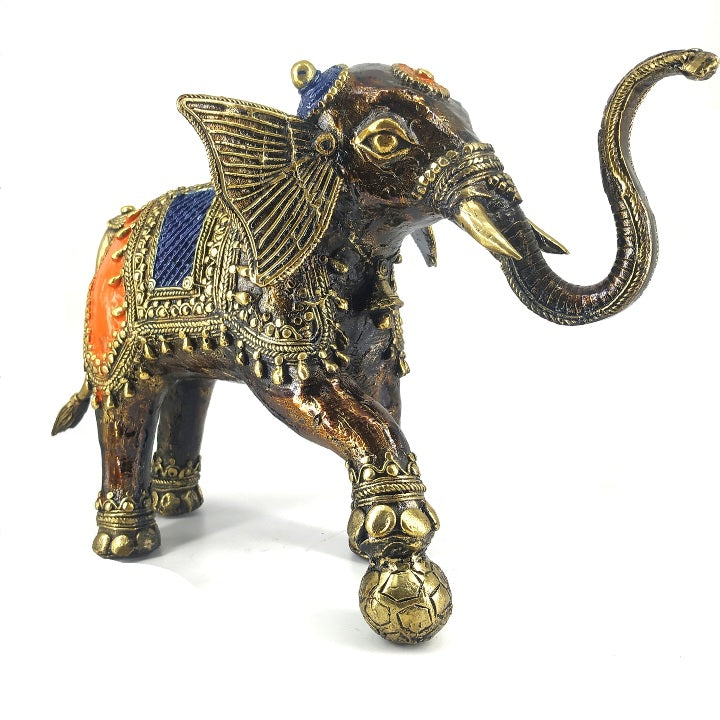 Front three-quarter view of bronze brass soccer playing elephant statue with blue and orange saddle detailing
